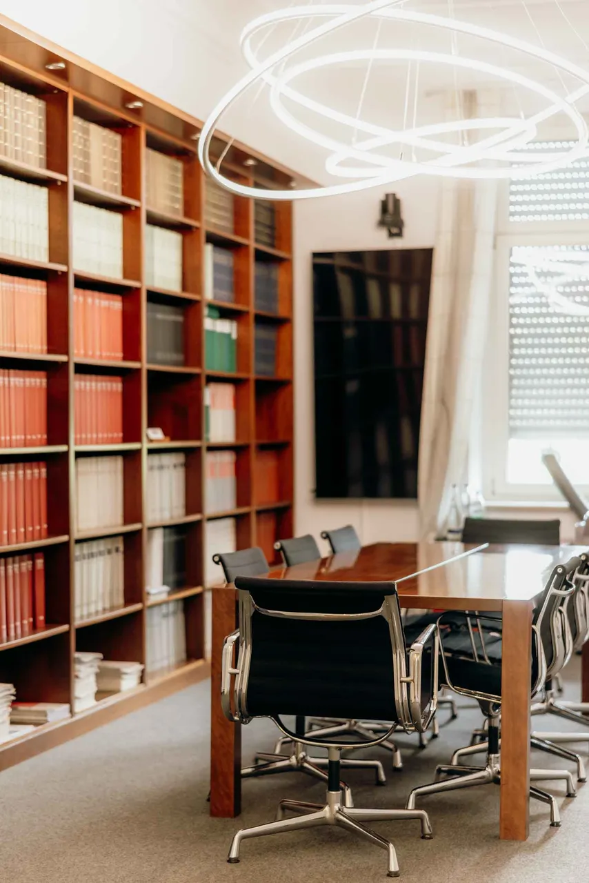 Bibliothek der Kanzlei RIFA mit Fachliteratur und Besprechungstisch